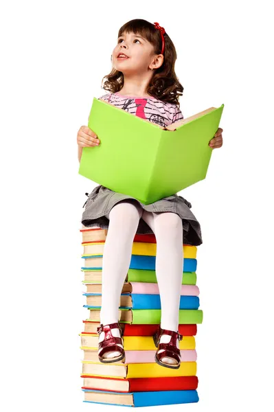 Маленькая девочка, сидя на стопку книг — стоковое фото