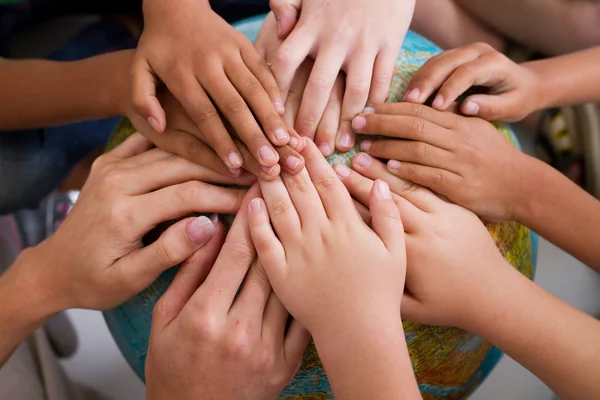 Разнообразие детские руки вместе на глобус — стоковое фото