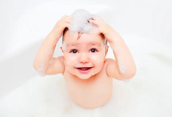 Счастливый ребенок, мытье в ванной комнате в пены — стоковое фото