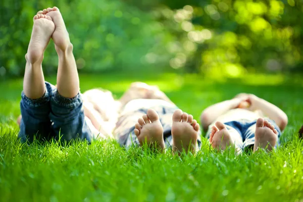 Счастливые дети, лежащие на зеленой траве — стоковое фото