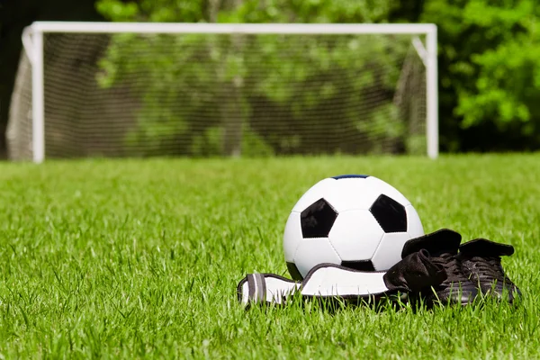 Детей спортивным концепт с футбольный мяч, бутсы, голени охранников на поле с копией пространства — стоковое фото
