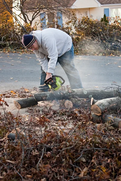 Человек отрубы веток деревьев с бензопилой — стоковое фото