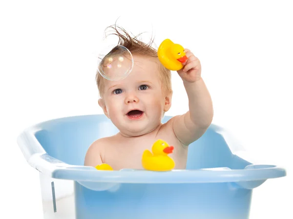 Очаровательный ребенок ванна в голубой ванной и играя с мылом bubb — стоковое фото