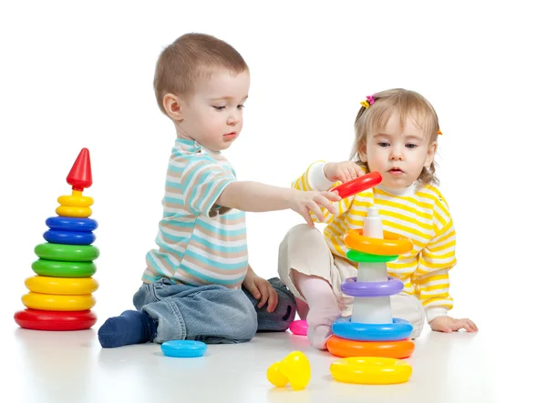 Два маленьких ребенка, играющие с цветными игрушками — стоковое фото