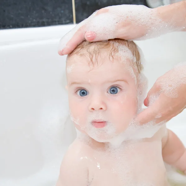 Мать, мытье волос ребенка в ванне — стоковое фото