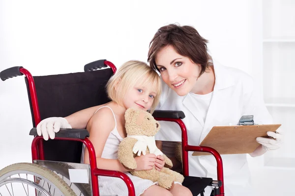 Уход медсестры и улыбаясь маленькая девочка пациента — стоковое фото