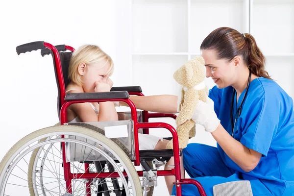 Медсестра пытается развеселить маленькую девочку — стоковое фото