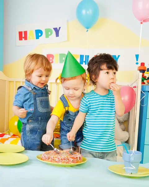 Три дети едят торт на день рождения участника — стоковое фото