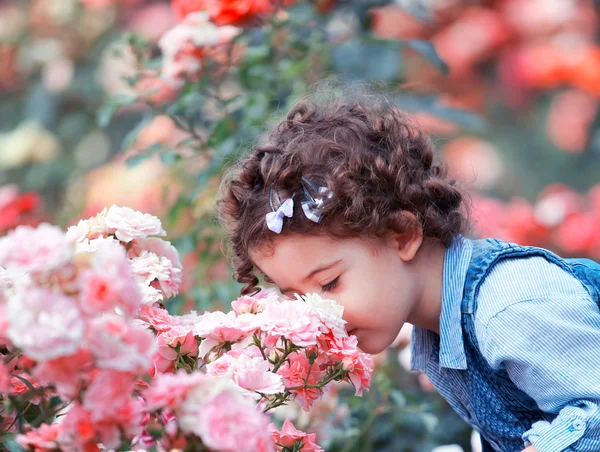 Девочка, пахнущий розовых роз — стоковое фото