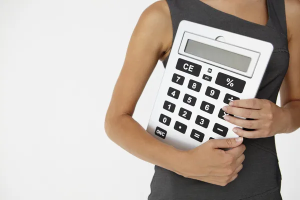 Молодая женщина-предприниматель с гигантским калькулятором — стоковое фото