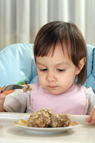 Мало кавказской малыш ест за столом — стоковое фото