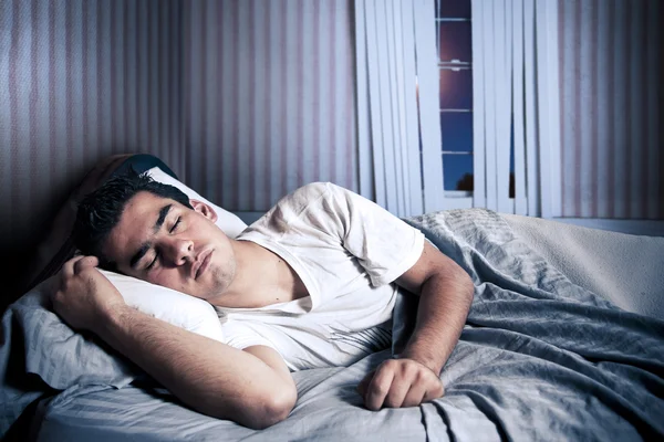 Человек, удобно спать в своей постели — стоковое фото